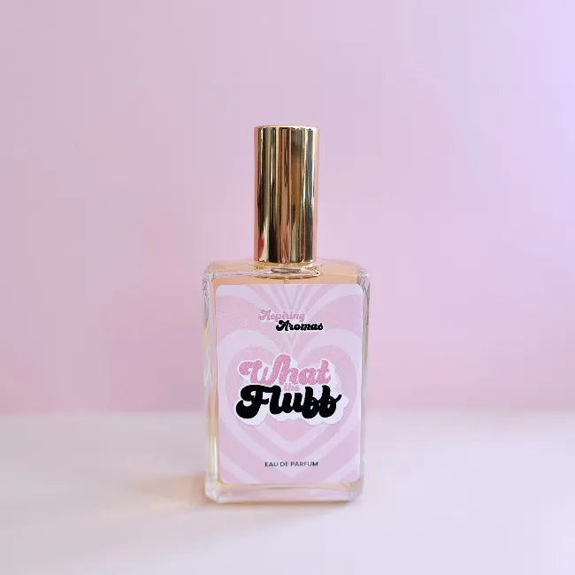 Glass perfume bottle labeled What The Fluff by aspiring aromas