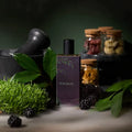Perfume bottle from Sorce labeled 'Witchery' with blackberries, green leaves, and jars in the background.